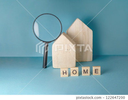 Magnifying glass is on a table with a house and some wooden blocks Magnifying glass is on a table with a house and some wooden blocks 122647200