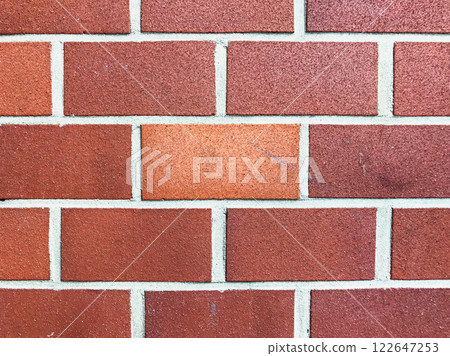 Brick wall with a red brick in the middle 122647253