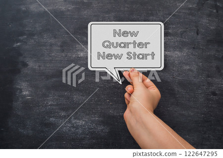 Hand holding a paper that says New Quarter New Start Hand holding a paper that says New Quarter New Start 122647295