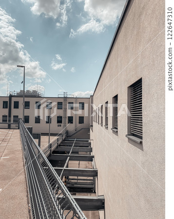 Building with a lot of windows and a fence Building with a lot of windows and a fence 122647310