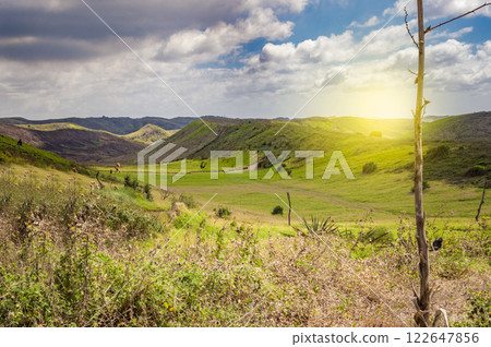 View of hills with clouds and blue sky, Meadow with green hills, Beautiful road leading to a hill 122647856