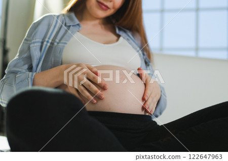 Pregnancy motherhood people expectation future. Pregnant woman hands touching big belly. Girl hugging her tummy enjoying pregnancy at home. Maternity tenderness parenthood new life concept Pregnancy motherhood people expectation future. Pregnant woman hands touching big belly. Girl hugging her tummy enjoying pregnancy at home. Maternity tenderness parenthood new life concept 122647963