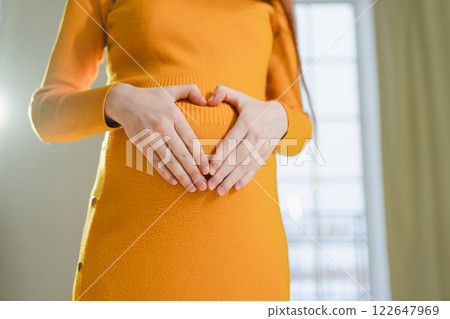 Pregnancy motherhood expectation future. Pregnant woman hands touching big belly. Girl making heart shape with hands enjoying pregnancy. Pregnant woman showing heart sign. Maternity love new life 122647969
