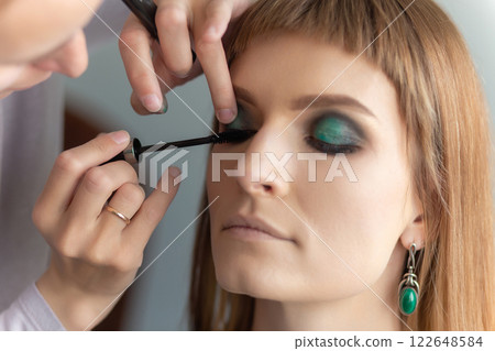 Portrait of make-up artist doing make-up girl. 122648584
