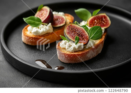 Minimalist food presentation featuring figs and cheese on toasted bread 122648790