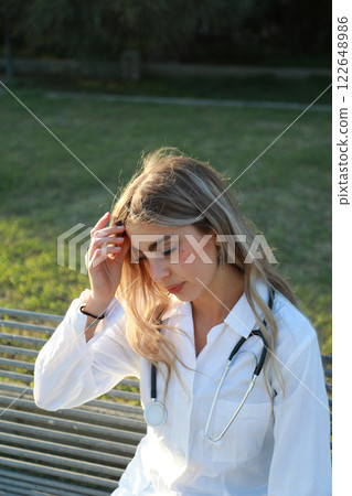 Tired Female Doctor Takes a Break Outdoors Tired Female Doctor Takes a Break Outdoors 122648986