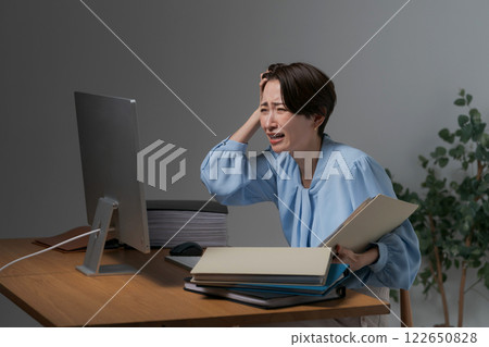 一位女士抱著頭看電腦 122650828