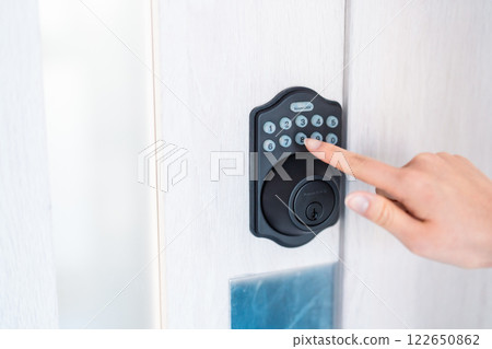 Fingers entering the door pin number, no face 122650862