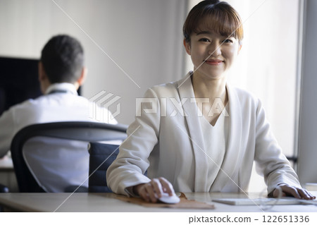 A woman working at a computer 122651336