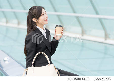 A young businesswoman relaxing with a takeaway coffee at OASIS21 Water Spaceship, Sakae, Nagoya A young businesswoman relaxing with a takeaway coffee at OASIS21 Water Spaceship, Sakae, Nagoya 122652659