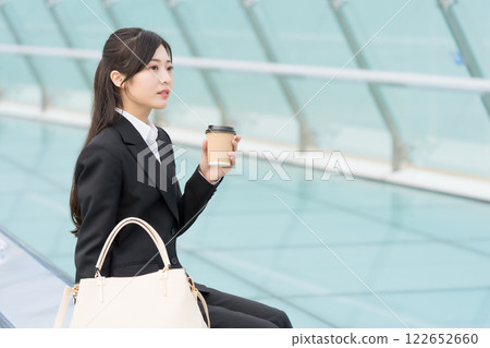 A young businesswoman relaxing with a takeaway coffee at OASIS21 Water Spaceship, Sakae, Nagoya 122652660