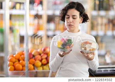 Adult woman chooses poke in grocery store 122654502