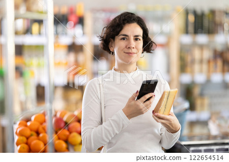 Adult woman scanning qr code for cheese Adult woman scanning qr code for cheese 122654514