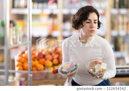 In store, woman near counter are looking at poke salad In store, woman near counter are looking at poke salad 122654542