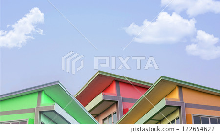 Simple colorful Concrete House with Roof in Village for Sale, Basic Home for Medium Small Family Residential, Blue Sky and Cloud in Background with Copy Space. Simple colorful Concrete House with Roof in Village for Sale, Basic Home for Medium Small Family Residential, Blue Sky and Cloud in Background with Copy Space. 122654622