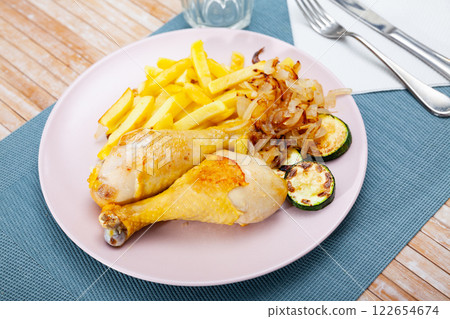 Chicken legs with fried potato and zucchini 122654674