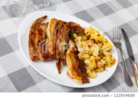 Fried lamb served with cauliflower on platter 122654689