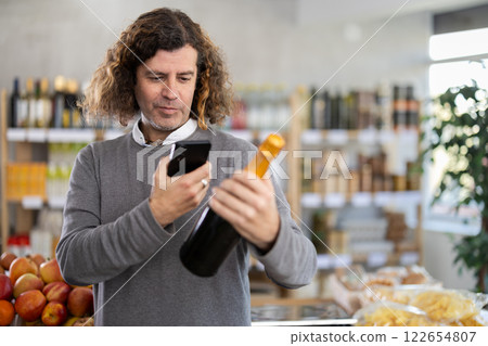 man scans a bottle of champagne 122654807
