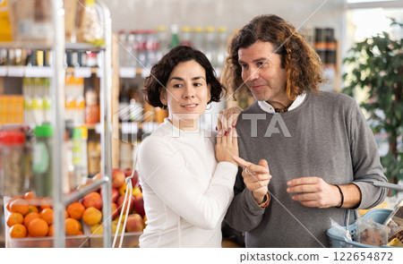 In store, couple looking for something on shelf of showcase 122654872