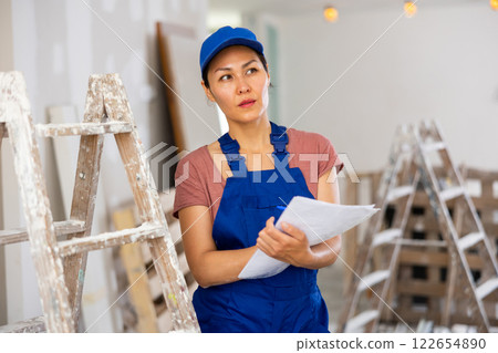 Female engineer matching check list during repair works Female engineer matching check list during repair works 122654890