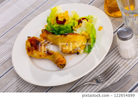 Chicken legs with greens and corn salad Chicken legs with greens and corn salad 122654899