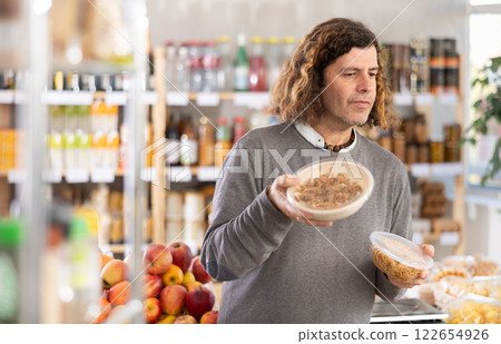 man holds a package of noodles in his hands man holds a package of noodles in his hands 122654926