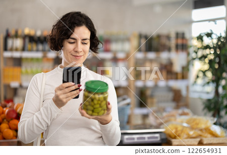 Adult woman scanning qr code of olives Adult woman scanning qr code of olives 122654931