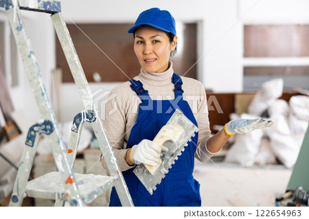 Portrait of female builder with construction painting tools Portrait of female builder with construction painting tools 122654963