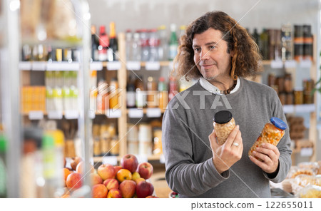 Man choosing cans of beans 122655011