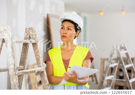 Woman builder checking project documentation 122655017