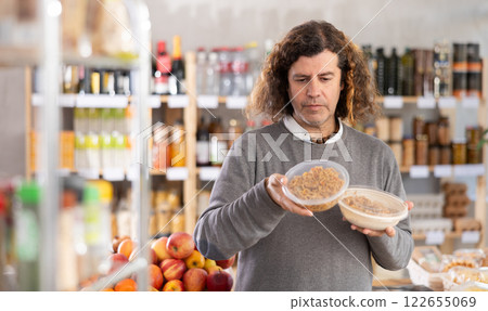 man holds a package of noodles in his hands man holds a package of noodles in his hands 122655069