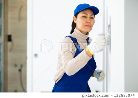 Portrait of female builder in process of finishing work in cottage Portrait of female builder in process of finishing work in cottage 122655074