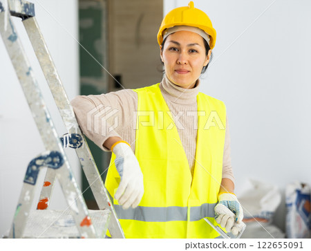 Portrait of female builder with construction painting tools Portrait of female builder with construction painting tools 122655091