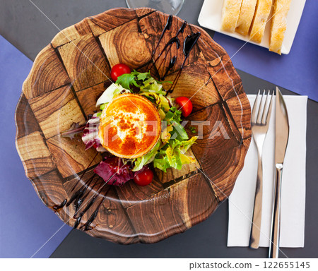 Vegetable salad with greens, tomatoes, grilled goat cheese, nuts 122655145