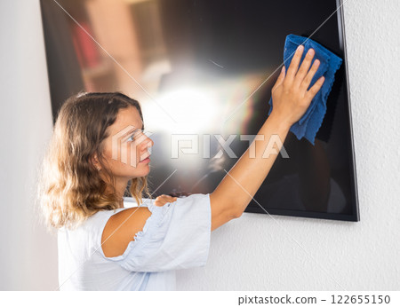 Woman doing housework - washing TV screen with dishcloth Woman doing housework - washing TV screen with dishcloth 122655150
