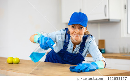 Skilled woman house cleaner sanitizing kitchen countertop Skilled woman house cleaner sanitizing kitchen countertop 122655157