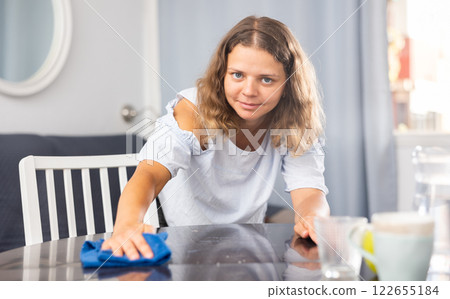 Young woman cleaning dining table at home Young woman cleaning dining table at home 122655184