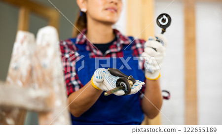 Blurred woman builder holding door handle Blurred woman builder holding door handle 122655189