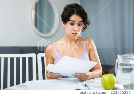 Portrait of troubled woman looking at papers Portrait of troubled woman looking at papers 122655225