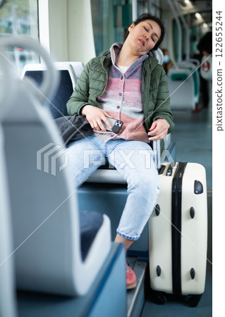 Tired asian woman fell asleep in subway car Tired asian woman fell asleep in subway car 122655244