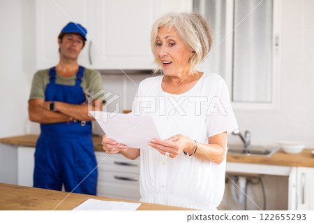 Positive mature woman homeowner reading contract papers 122655293