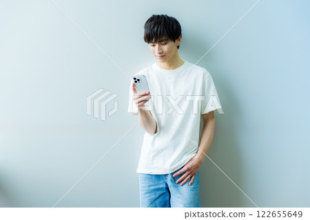 A young man operating a smartphone A young man operating a smartphone 122655649