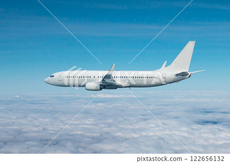 White passenger airliner flying in the air above the clouds 122656132