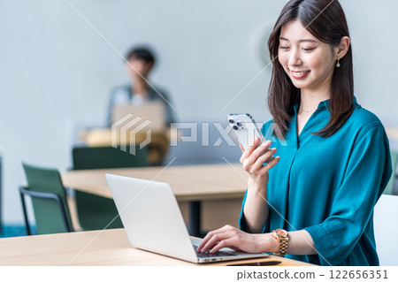 A woman working in a coworking space. A woman working in a coworking space. 122656351