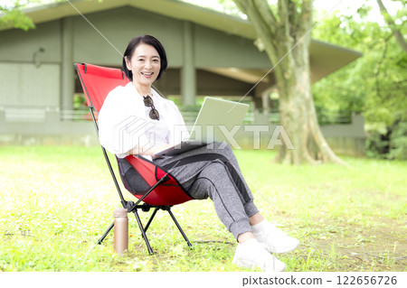 Workcation: Middle-aged woman working in the park Workcation: Middle-aged woman working in the park 122656726