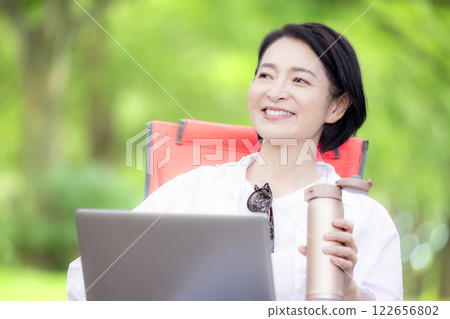 Workcation: Middle-aged woman working in the park Workcation: Middle-aged woman working in the park 122656802