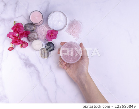 Woman hand holding natural body scrub in a spa salon 122656849