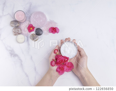 Woman hand holding natural body lotion in a spa salon 122656850