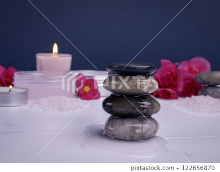Shower gel flowing on spa stones with body care products, flowers and candles 122656870