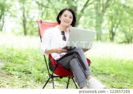 Workcation: Middle-aged woman working in the park 122657289